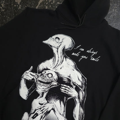 Black Always Smile Pullover Hoodie by Any Means Necessary Clothing, featuring a close-up of the smiling graphic on the front.