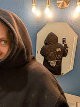Black Mantra Zip Up Hoodie by Any Means Necessary Clothing, front view showing hoodie with zipper and logo detail.