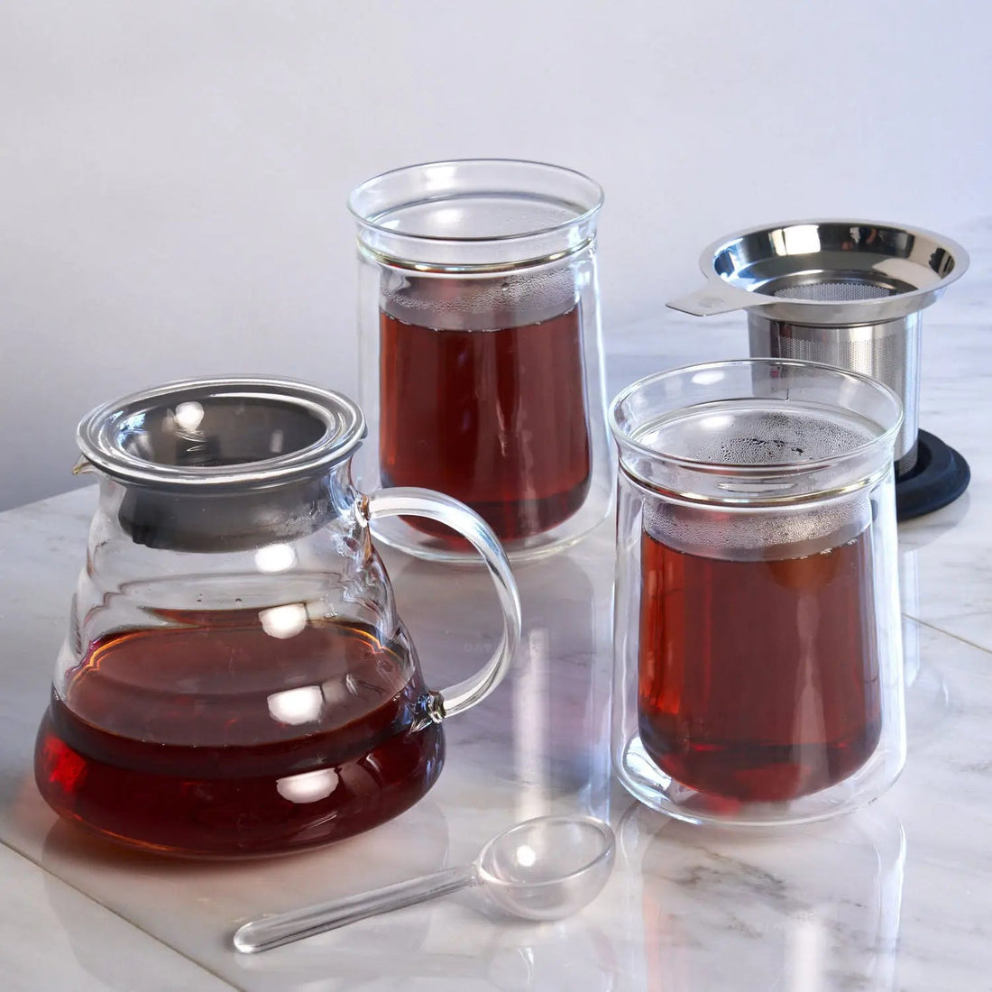 Silver tea for two set by August Uncommon Tea, includes two teacups and a matching teapot for a cozy tea experience.