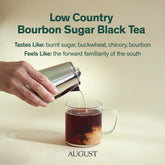 Black tea from August Uncommon Tea, Low Country Bourbon Sugar Black Tea, in a clear glass cup with dark amber liquid and tea leaves visible.