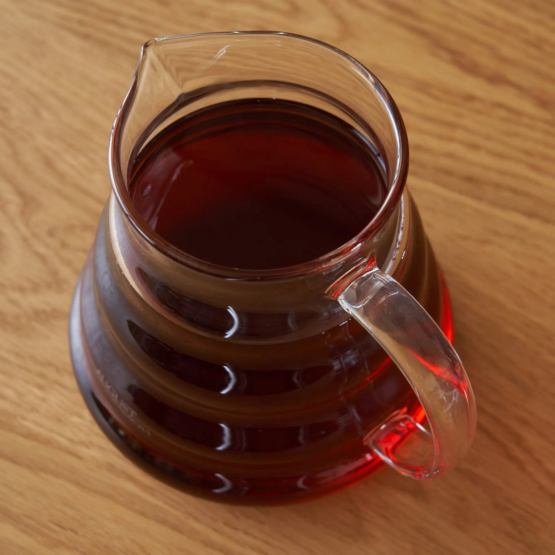 Two cup glass teapot by August Uncommon Tea, transparent teaware for brewing and serving tea, showcasing its clear glass design.