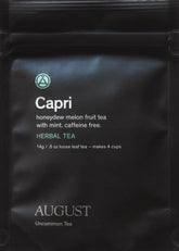 Cup of August Uncommon Tea Capri Honeydew Melon Mint herbal tea in a glass mug, showcasing fresh honeydew melon and mint leaves.