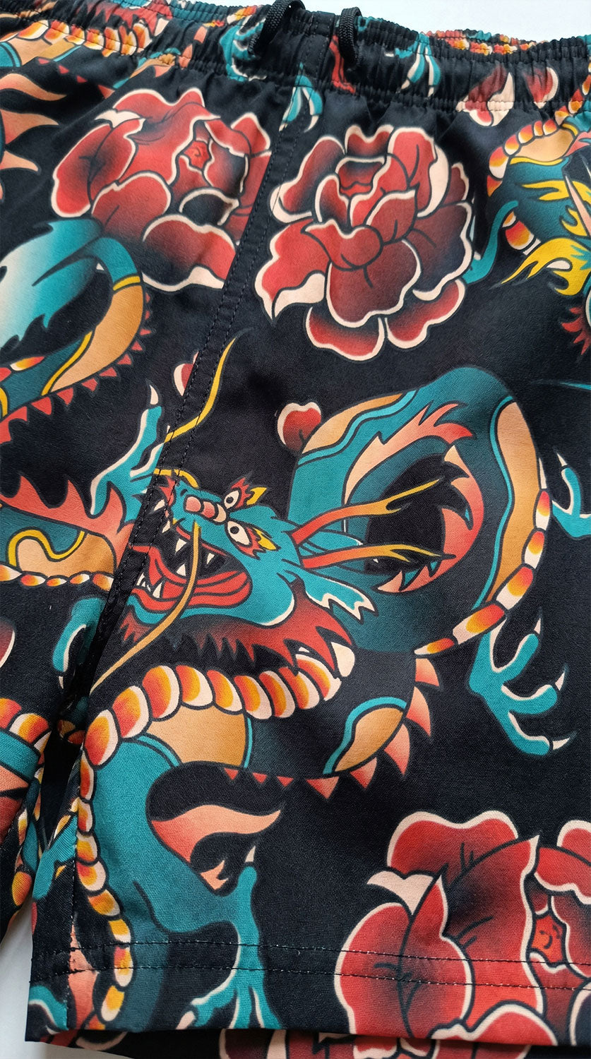 Black Dragon Tattoo Shorts by Yūjin Clothing featuring intricate dragon design on lightweight fabric.