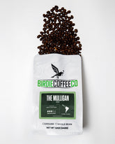 Ground decaf coffee by Birdie Coffee Company called The Mulligan, showcasing rich, aromatic coffee grounds in a bag.
