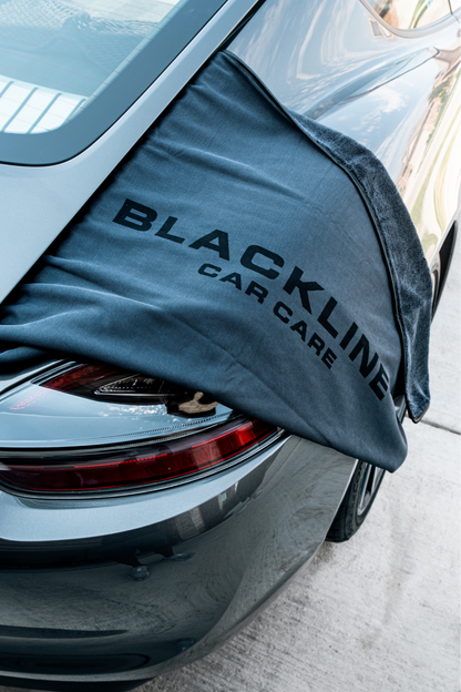 Blackline Car Care BLACKLINE® Slim Twisted-Loop Drying Towel draped over a car, showcasing its lightweight, textured cotton design.