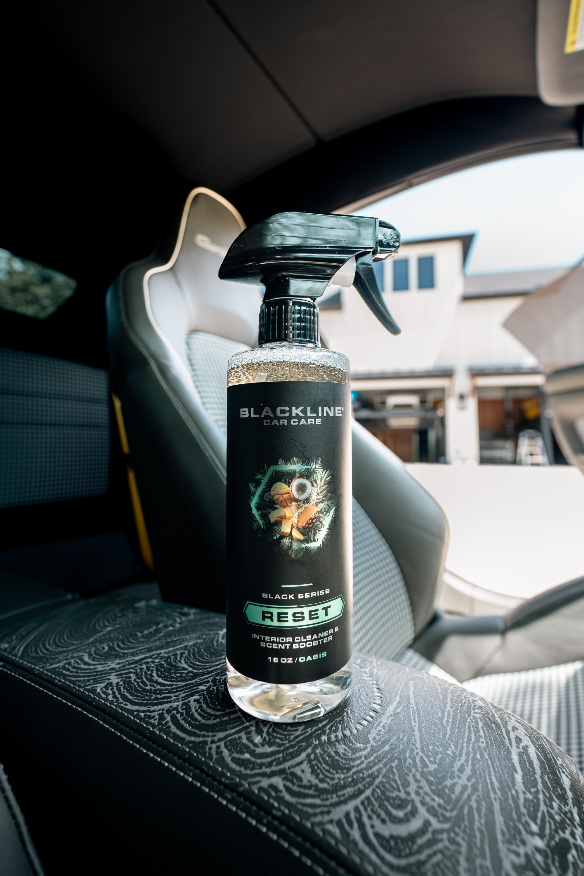 Blackline Car Care BLACKLINE® Reset interior cleaner and scent booster in a spray bottle, shown in a clean, modern interior setting
