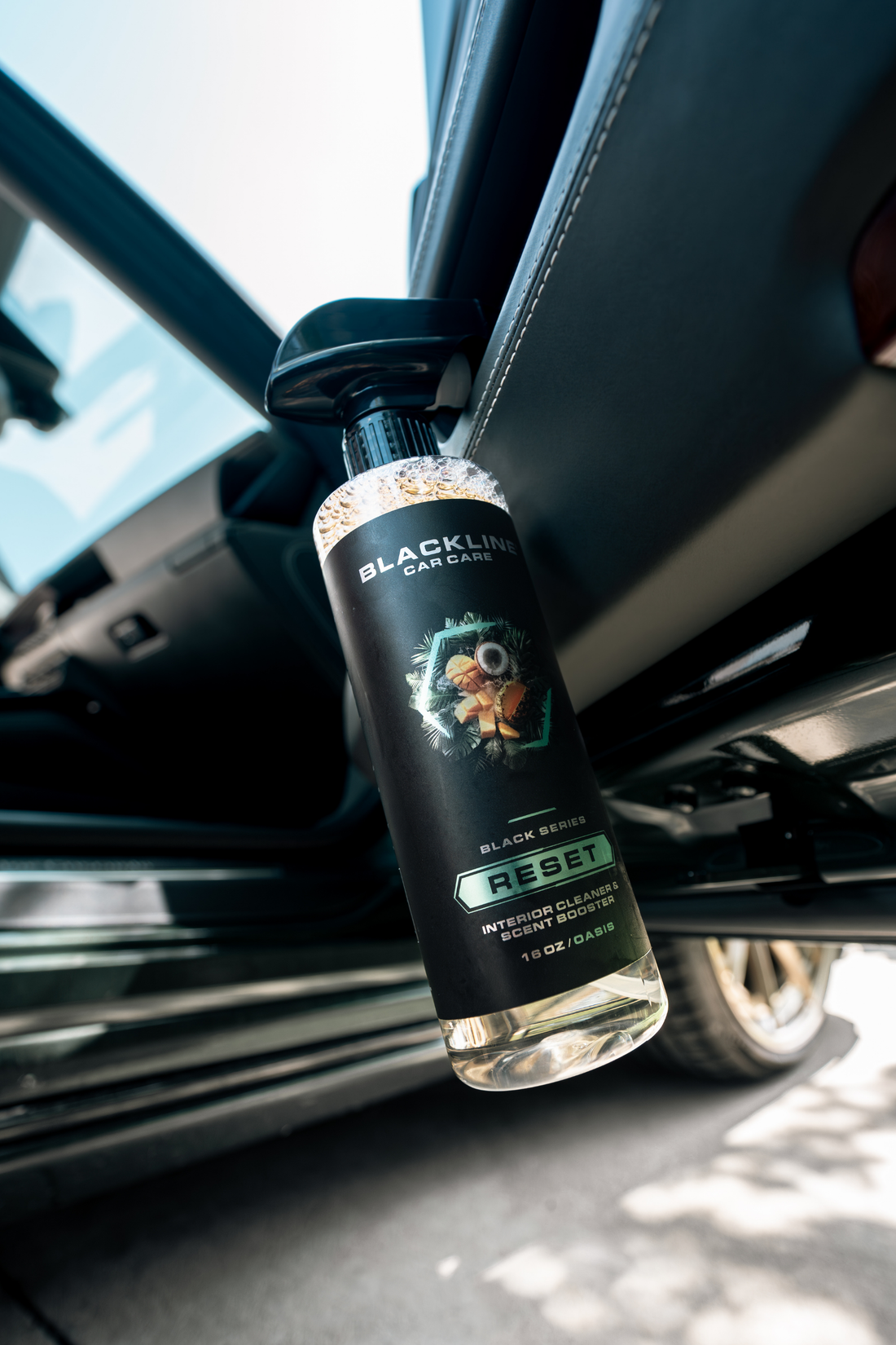 Blackline Car Care BLACKLINE® RESET interior cleaner and scent booster bottle close-up showing branding and product details.