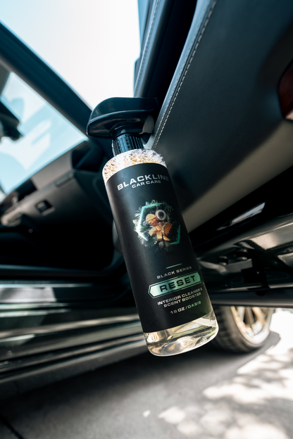 Blackline Car Care BLACKLINE® RESET interior cleaner and scent booster bottle close-up showing branding and product details.