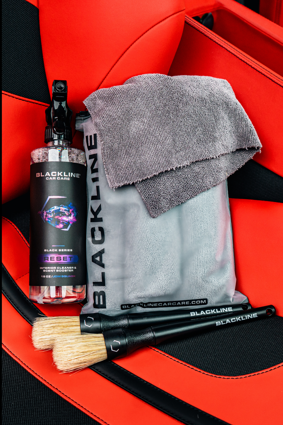 Blackline Car Care BLACKLINE® Reset interior cleaner and scent booster in a Ferrari F12 seat, showcasing the complete system.