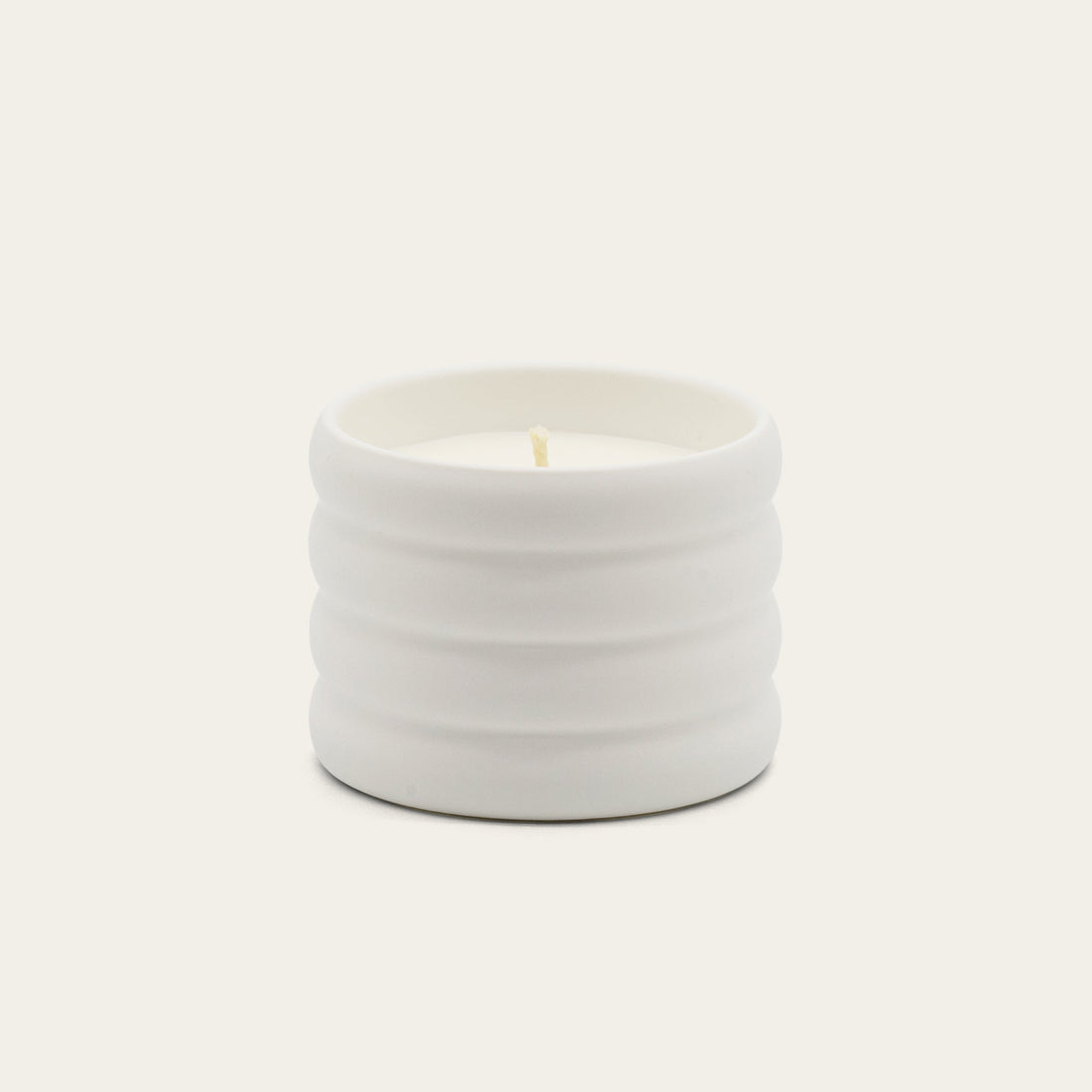 Soy wax ceramic candle by Italic, featuring a salted design, with a smooth white ceramic container and a lit wick for cozy ambiance.