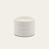 Soy wax ceramic candle by Italic, featuring a salted design, with a smooth white ceramic container and a lit wick for cozy ambiance.