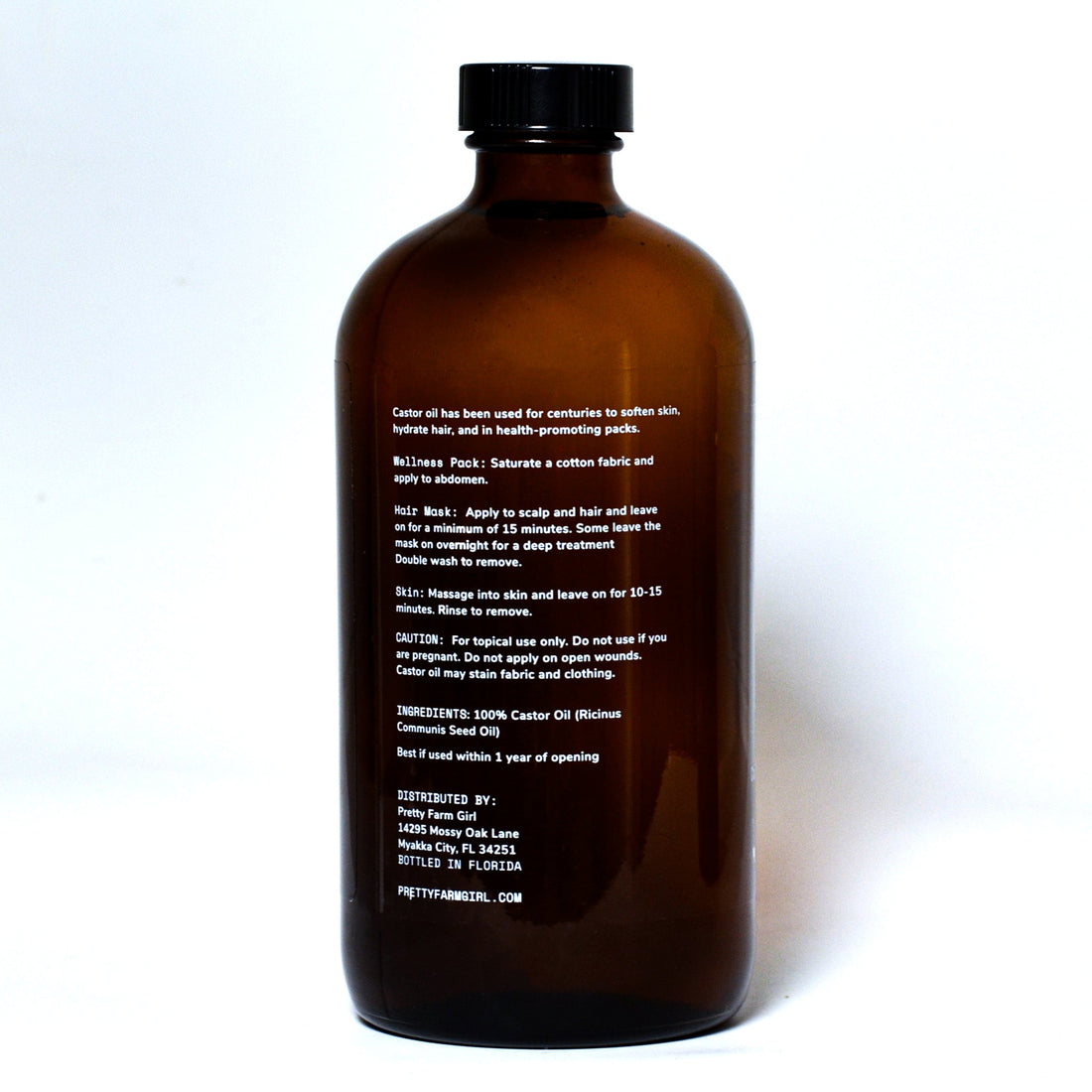 Pure organic cold pressed hexane-free castor oil bottle from Pretty Farm Girl, showing golden castor oil in a clear glass container.
