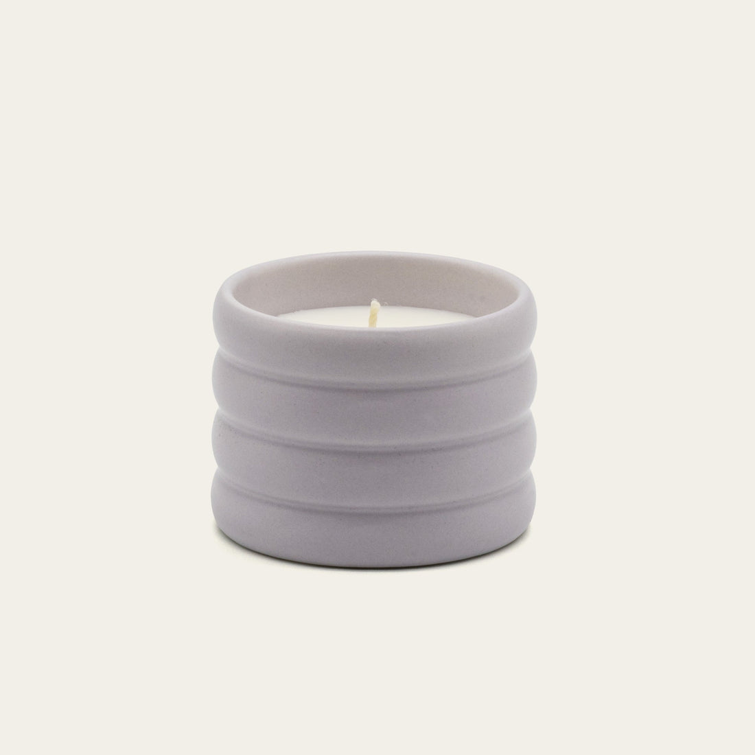 Lilac soy wax ceramic candle by Italic, showcasing a sleek ceramic container with a lit wick and soft candle glow.