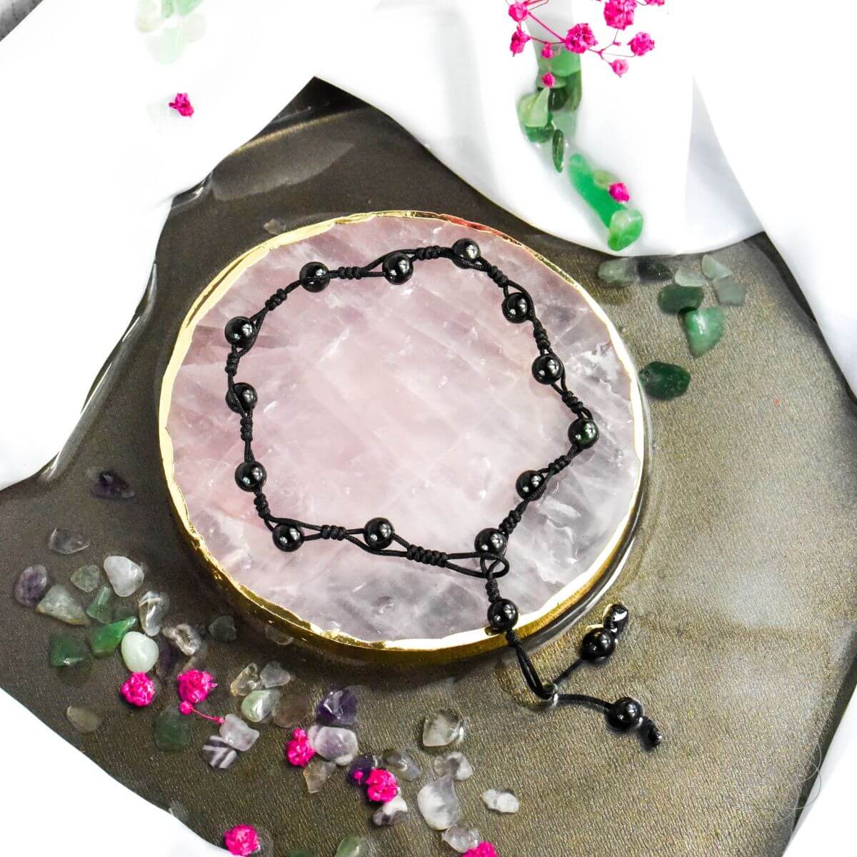 Black obsidian grounding anklet with beaded design, featuring a silver clasp, worn around the ankle for spiritual balance and style.