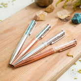 Set of manifestation pens from Conscious Items for abundance and positive energy, featuring inspirational designs and vibrant colors.