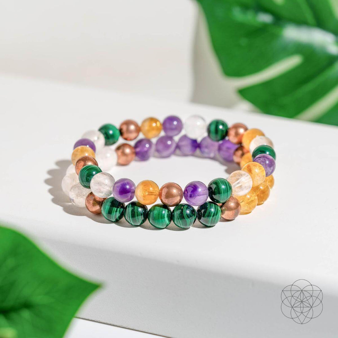 Set of four crystal bracelets for wealth manifestation by Conscious Items, featuring polished gemstone beads in vibrant colors.