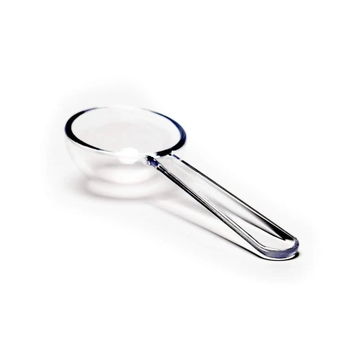 August Uncommon Tea teaware with a clear glass scoop and crystals, ideal for brewing and serving tea.