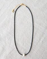 Downeast pearl and cord necklace featuring a string of white pearls on a black cord, stylish and elegant jewelry accessory.
