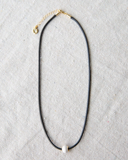 Downeast pearl and cord necklace featuring a string of white pearls on a black cord, stylish and elegant jewelry accessory.