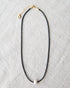 Downeast pearl and cord necklace featuring a string of white pearls on a black cord, stylish and elegant jewelry accessory.