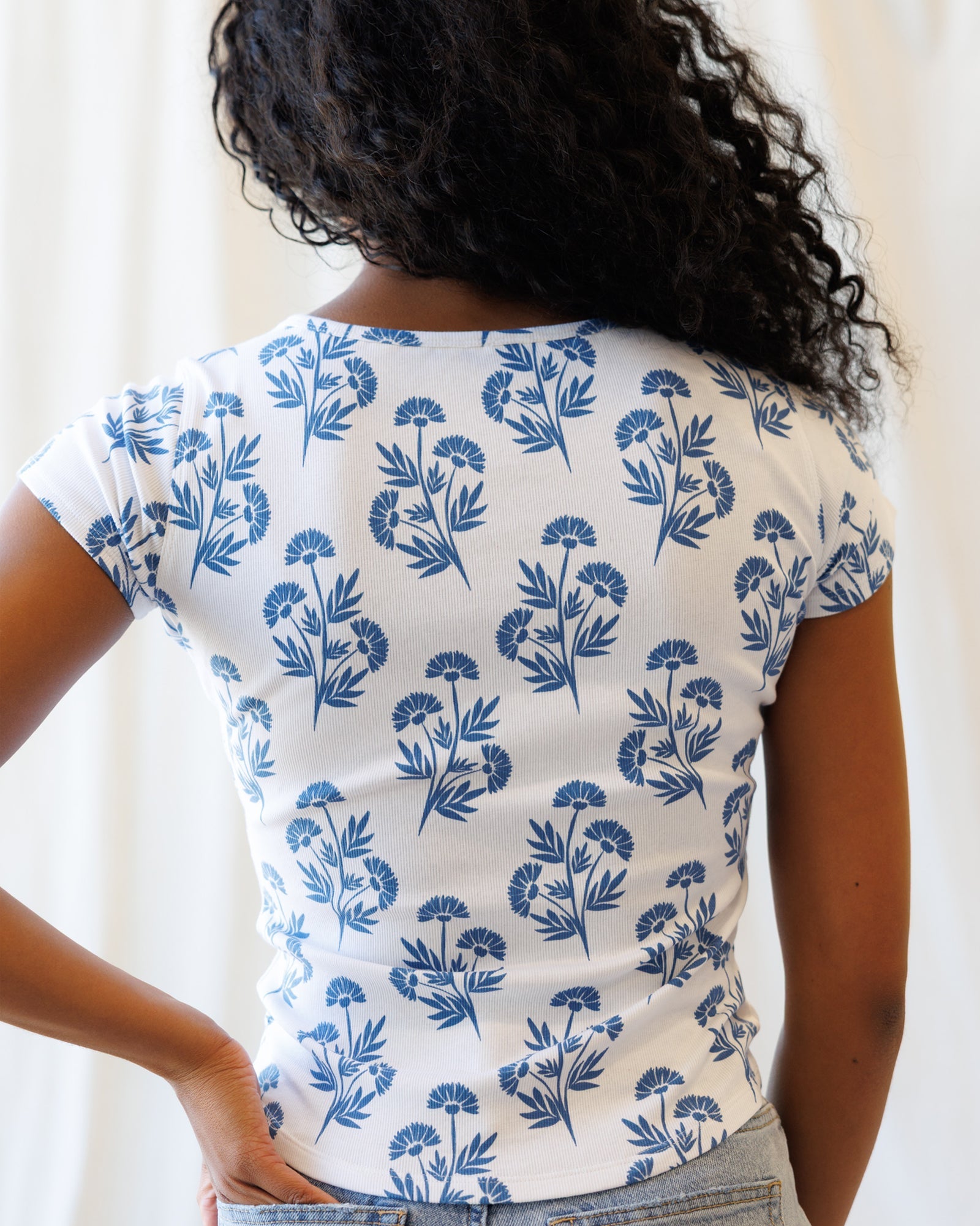 Downeast Artistic Tee, a stylish casual top with artistic design, displayed on a hanger against a neutral background.