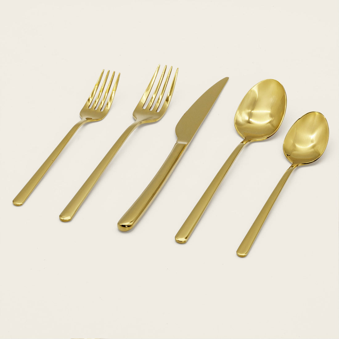 Italic Emilia Mirror 20-piece gold flatware set with sleek, modern design and polished finish displayed on a white background.