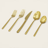 Italic Emilia Mirror 20-piece gold flatware set with sleek, modern design and polished finish displayed on a white background.