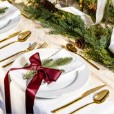 Italic Emilia 20-piece gold flatware set including forks, knives, spoons, and teaspoons arranged on a table.