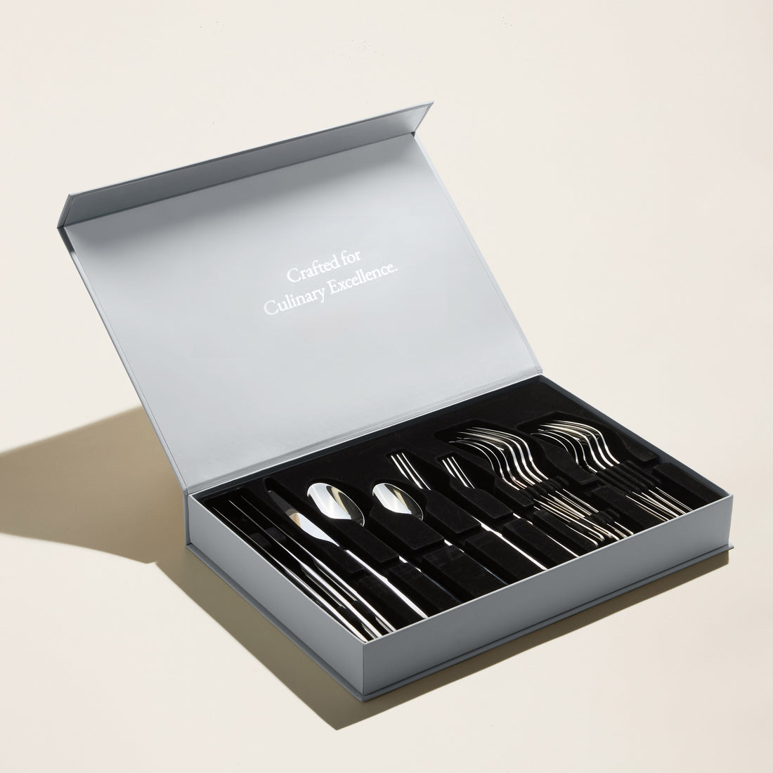 Italic Emilia 20-piece silver flatware set featuring polished forks, knives, spoons, and teaspoons arranged on a white background.