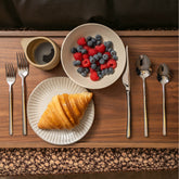 Italic Emilia Mirror 20-Piece Flatware Set with polished stainless steel finish, including forks, knives, and spoons arranged on a table.