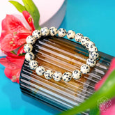 Dalmatian Jasper bracelet from Conscious Items featuring black and beige spotted stones, designed for emotional detox and healing.
