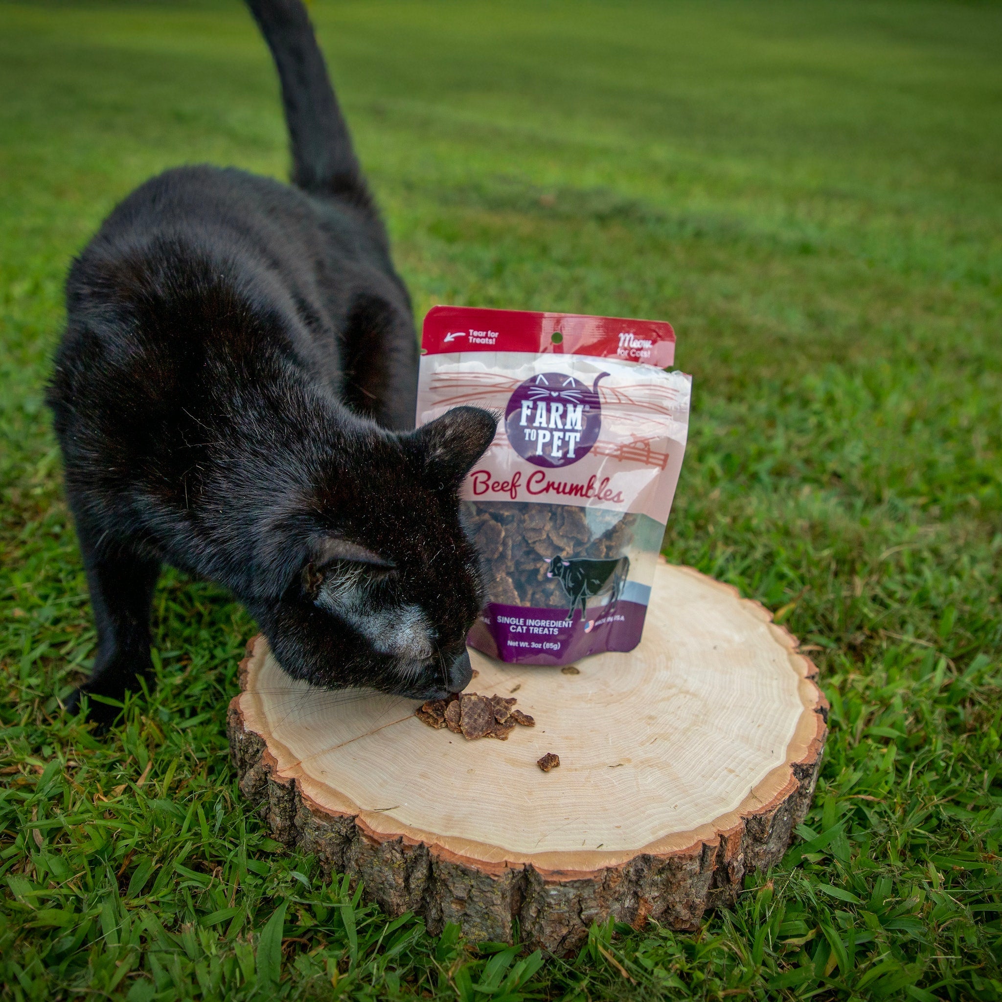 Farm To Pet beef crumbles cat treats in a bag, showing a cat sniffing the front of the package, high-protein snack for cats.