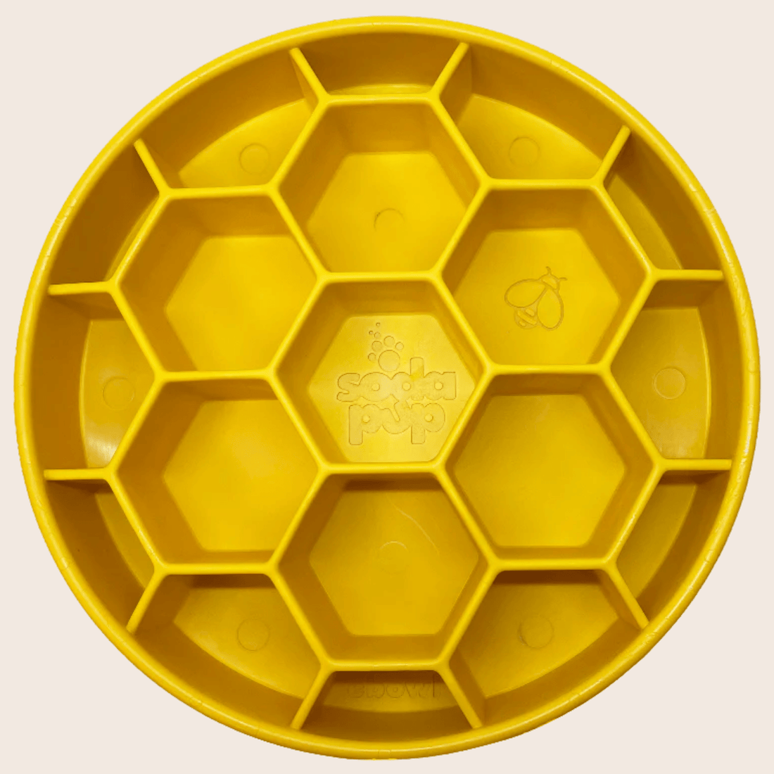 Close-up of yellow Farm To Pet slow feeder dog bowl with honeycomb design, made for preventing rapid eating in dogs.