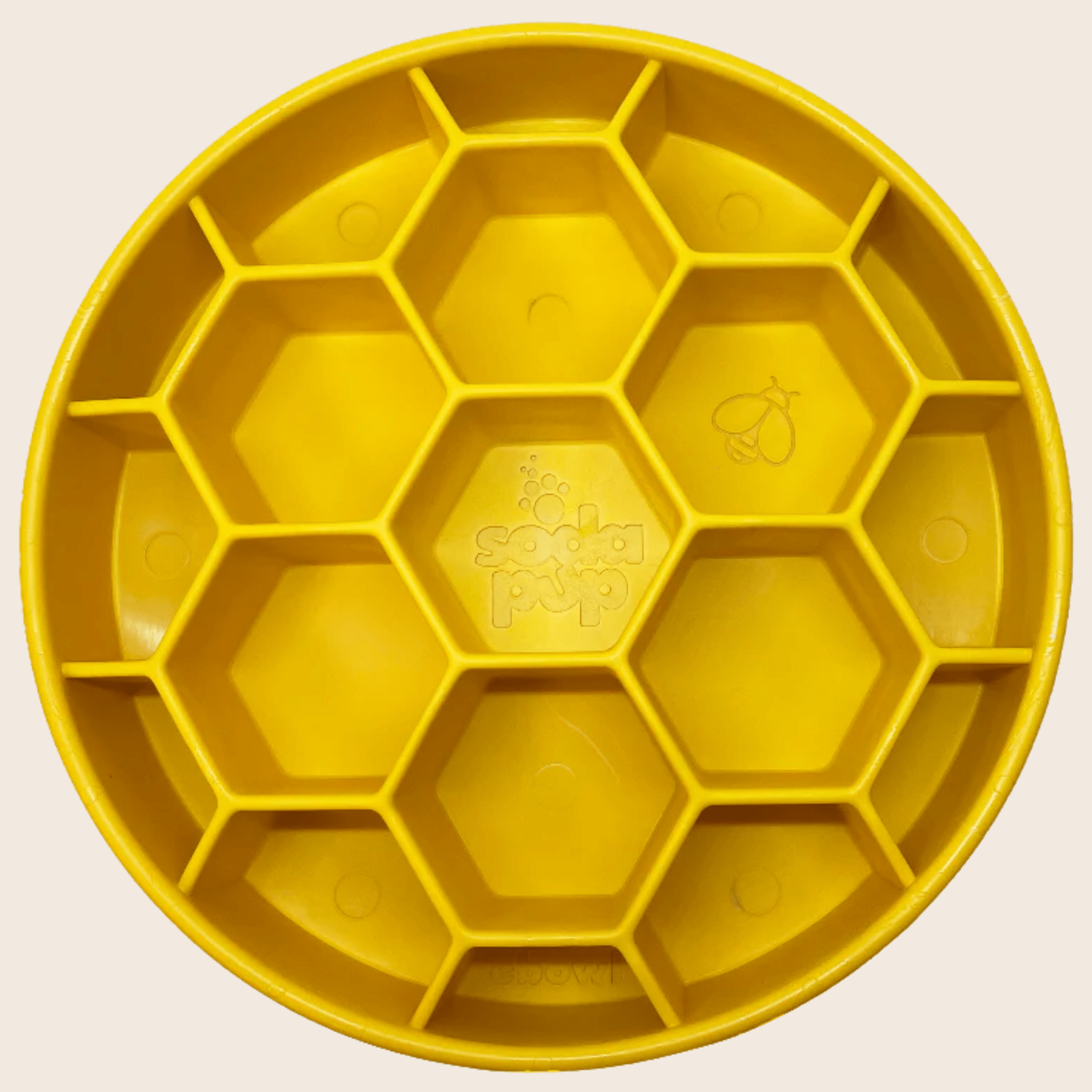 Close-up of yellow Farm To Pet slow feeder dog bowl with honeycomb design, made for preventing rapid eating in dogs.