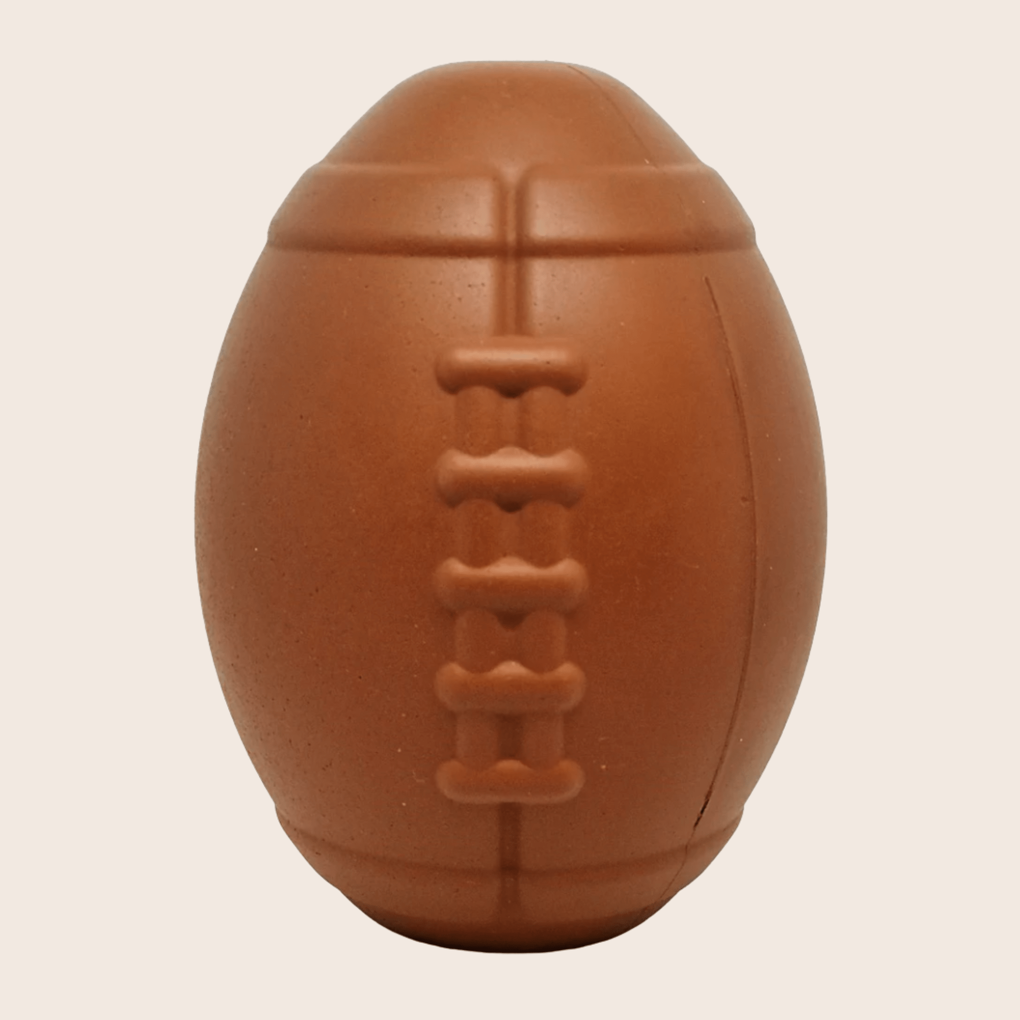 Farm To Pet dog treat dispenser in brown with football shape, close-up view showing the textured surface and dispensing opening.