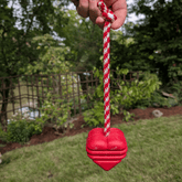 Farm To Pet tug toy with a heart on a string, designed for dogs to chew and play, close-up view showing soft fabric and heart detail