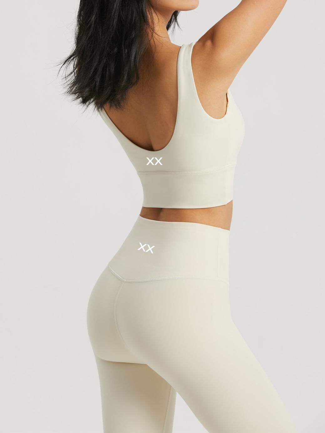 Off-white BLACKOUT BARBELL Omni Bra displayed on a mannequin, showing its sleek design and supportive fit for active wear.