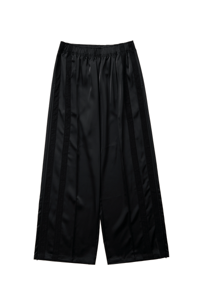 Black Leiseu track pants by findmenowthelabel, flat lay showing elastic waistband and relaxed fit for casual wear.