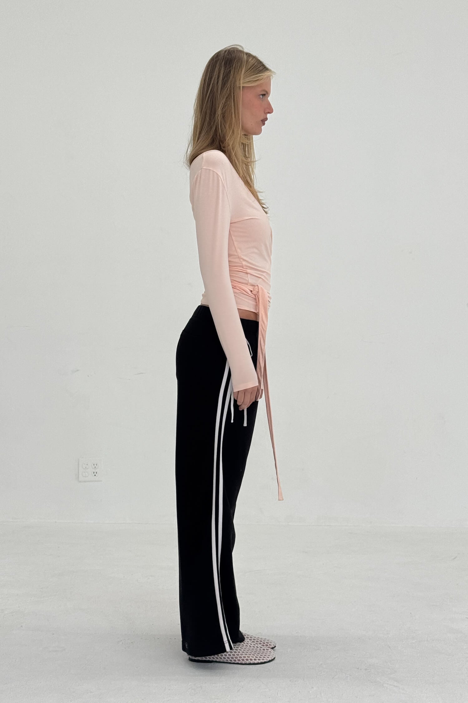 Black French Terry Bow Jogger pants by findmenowthelabel, showing the relaxed fit and elastic waistband detail.