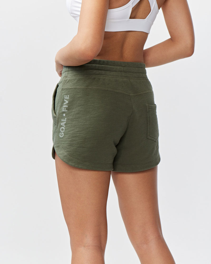Goal Five Freasy Short in dark moss color, lifestyle shot showing comfortable fit and casual style on model.