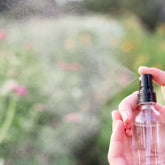 Pretty Farm Girl organic turmeric facial toner spray for evening skin tone, featuring a clear bottle with yellow liquid and spray nozzle.