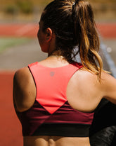 Goal Five Pionxr training bra top in rose cinnabar nectar, shown on a model, with a fitted athletic design for active wear.