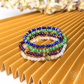 Set of four Good Karma jewelry bracelets by Conscious Items featuring symbols of luck and success on colorful beaded designs.