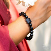 Black obsidian and tourmaline bracelet from Conscious Items featuring smooth, round beads on a stretch cord.