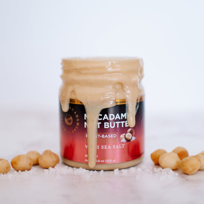Jar of House of Macadamias macadamia nut butter with sea salt flavor on a white background, showing the product label and creamy texture
