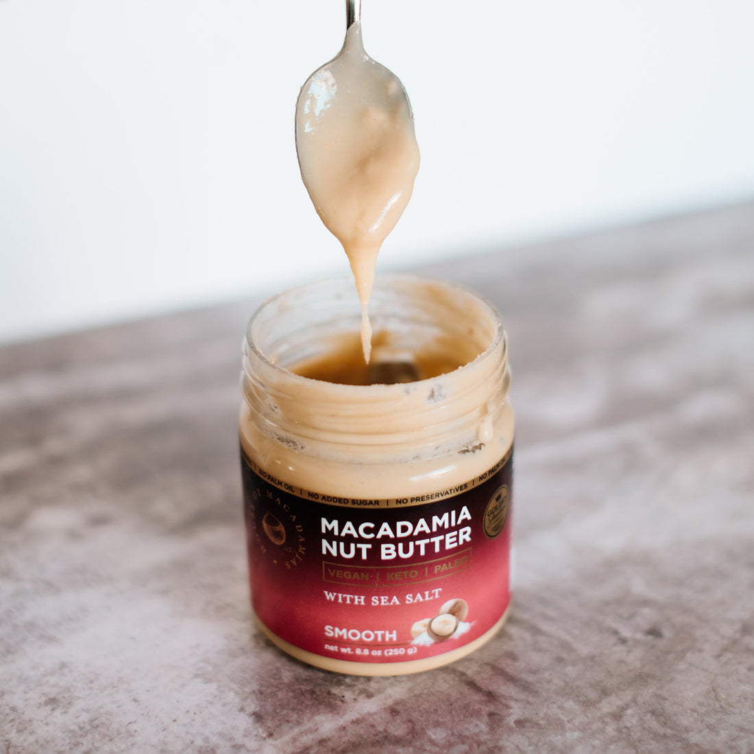 Jar of House of Macadamias sea salt macadamia nut butter showing the nutty spread in a clear jar with a label.