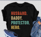 Mens graphic T-shirt by Spun Bamboo featuring "Husband, Daddy, Protector, Hero" text in bamboo viscose and organic cotton fabric.