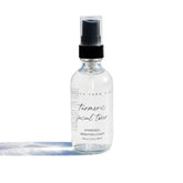 Pretty Farm Girl organic turmeric facial toner in a clear bottle, showing the hydrosol toner for evening skin tone.