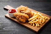 Igotchu Seasonings fried chicken and fish coating mix on a plate with French fries, showcasing crispy, seasoned fried food.