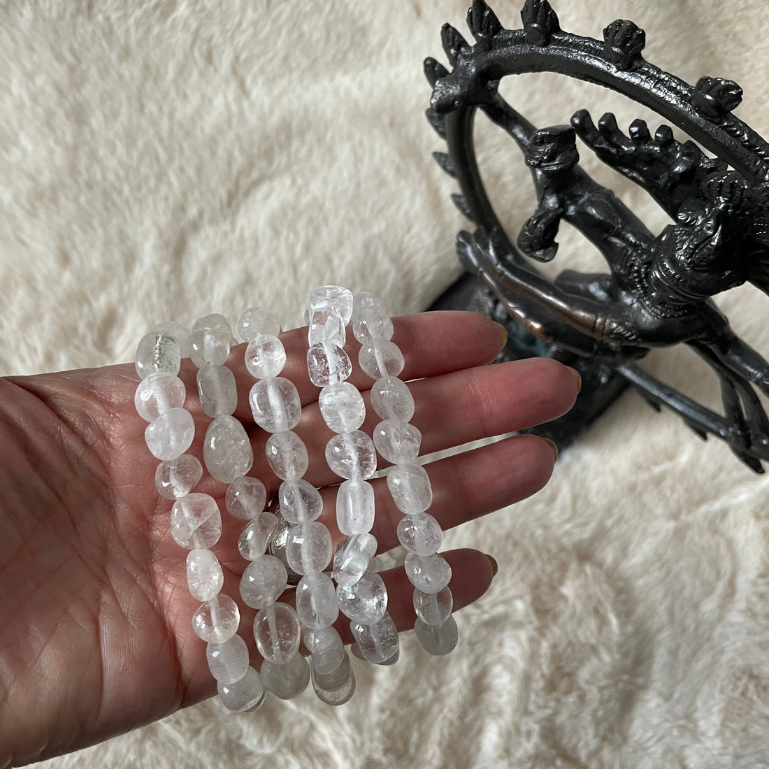Tumbled clear quartz stretch bracelet with smooth, polished beads from Evermore Everlasting displayed on a neutral background.
